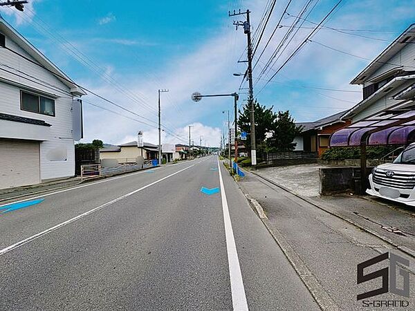 広々とした前面道路に面し、車の出し入れがしやすい現地外観。ゆとりある駐車スペースと開放感のある立地が魅力で、毎日の暮らしに快適さと安心をもたらすマイホームです。