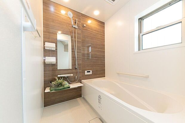 木目調の壁が心休まる空間を演出する浴室です。大きめの浴槽でゆったりと足を伸ばし、1日の疲れを癒してください。/施工例