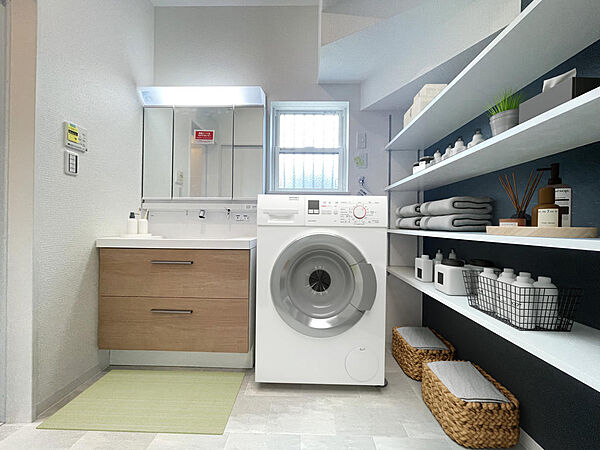 【洗面室・施工例】広々とした洗面室。可動式の棚を設置し、収納スペースもしっかり確保しました。洗剤類のストックやタオル類、入浴後の着替えなども置いておくことができます。