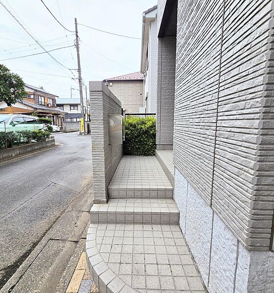 【 アプローチ 】玄関から道路までの間をやさしくつなぐアプローチ。交通量は少なくても安心は重ねたい。小さな優しい段差で家族に寄り添ってくれます。ポストの確認がしやすい設計もうれしい！。