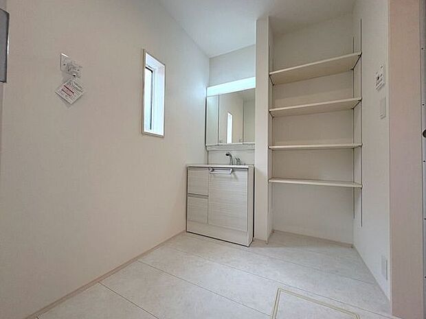 シャワー機能付き三面鏡の洗面化粧台。可動棚も完備しており、リネン類の保管も可能です!