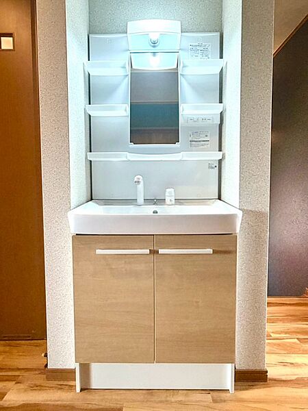 清潔感あふれるシンプルな洗面化粧台。機能的な収納スペースで、朝の忙しい時間もスムーズに身支度。毎日を気持ちよくスタートできる、使いやすい設備です。