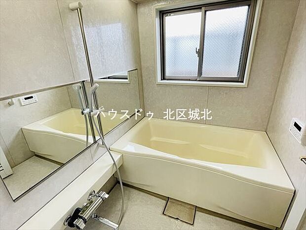 大きな鏡と大きな窓が特徴的な清潔感のある浴室です。