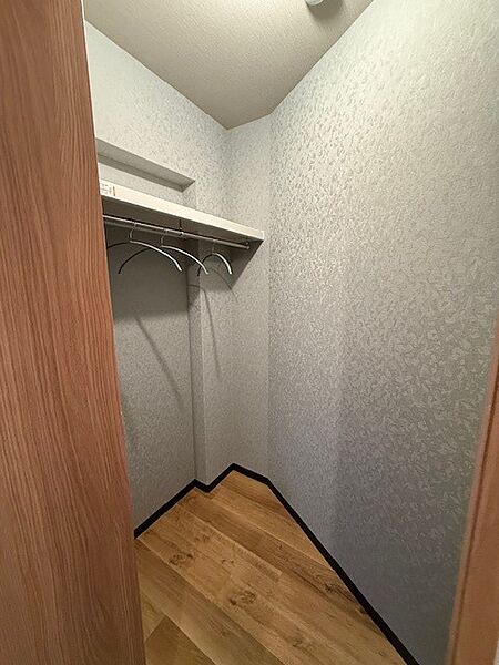 ウォークインクローゼットを備えた洋室。衣類をまとめて収納できます。