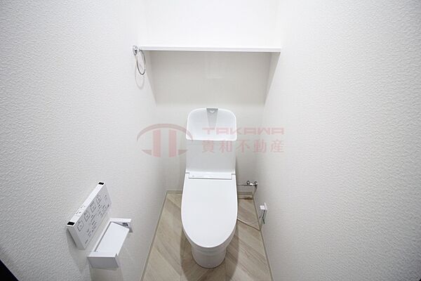 上部に便利な棚を備えた温水洗浄便座付きの快適なトイレ空間