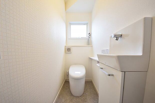 格子柄のアクセントクロスが可愛いトイレ　タンクレスですっきり広い空間