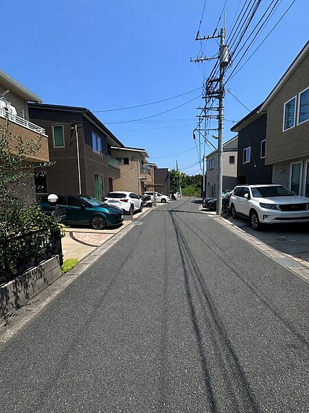 物件前面の道路です。幅員約5mでゆとりがあり、駐車時の取り回しもしやすい広さです。周囲は戸建て中心の住宅街で、開発分譲地内の整った街並みが広がります。お車の出入りもスムーズに行えます。