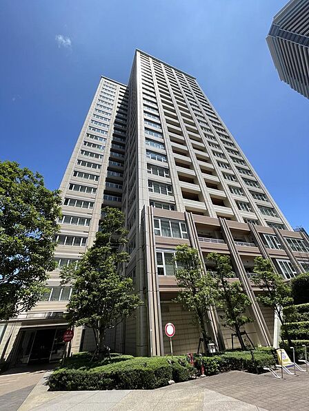 青空に向かって伸びるタワー棟の外観です。落ち着いた色合いのタイル貼りで、各住戸にバルコニーが設けられています。ご家族で長く安心してお住まいいただける住まいです。
