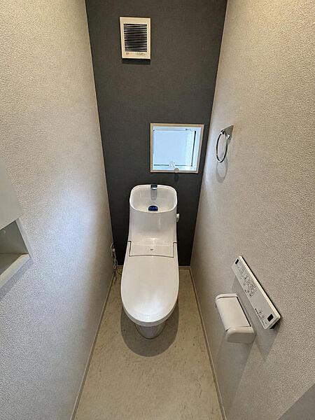 2階のトイレです。手すりが付いており、アクセントクロスで落ち着いた雰囲気にまとめられています。1階にもトイレがあるため、朝の混み合う時間帯も助かります。