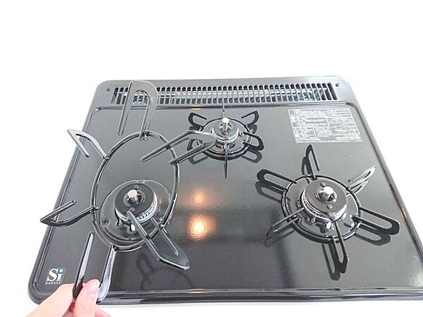 【同仕様写真】新品交換予定のキッチンにはコンロが3口ありお料理の同時進行が可能です。ワンタッチ着火で押すだけ、レバーで火力調整など操作も簡単です。また五徳が楽に取り外せるのでお掃除がしやすいですよ。