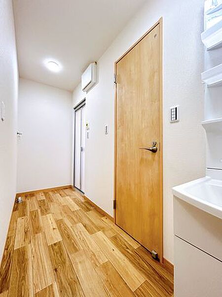 【リフォーム済】洗面所の写真です。洗面台横にはトイレの入り口がございます。