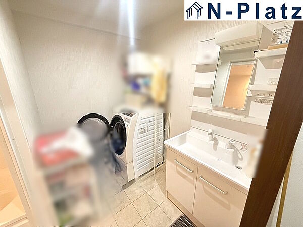 収納付き洗面台で、洗面用品もきれいに整理できます。脱衣スペースにゆとりがあり、使い勝手の良い水回りです。