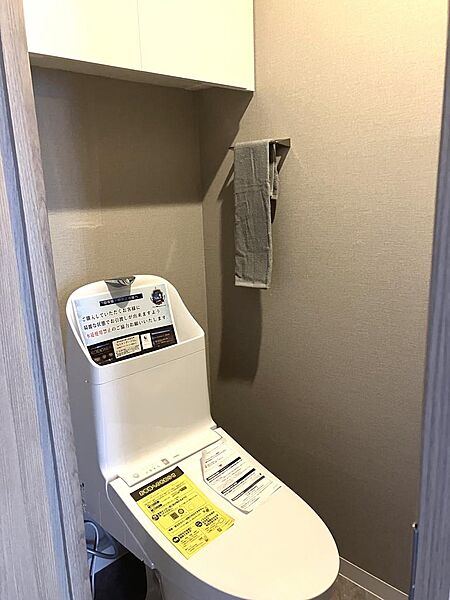 温水洗浄機能付きトイレも新規交換済。上部に棚があります。