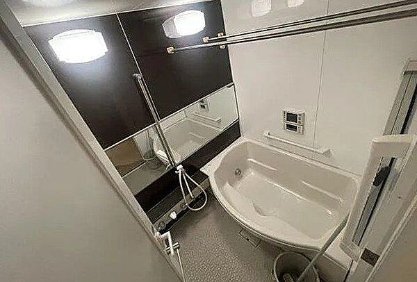 木目調のアクセントパネルが癒しの空間を演出するバスルームです まるでホテルのような高級感がありながら 日々の疲れをリセットできる落ち着いた雰囲気ですね 丁寧に使用されてきた清潔な状態です