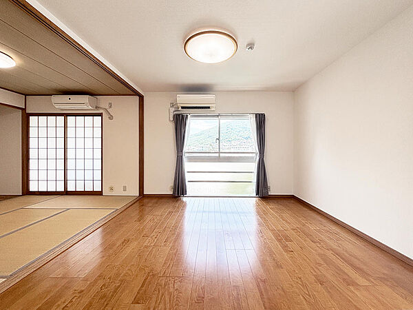 【リビング】窓から見る風景は、空を広く感じることができます。山に登るケーブルや、生駒線の電車も景色に彩りを与えてくれます。