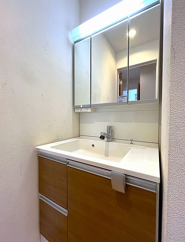 洗面台には三面鏡を採用。身だしなみを整えやすく、鏡の後ろに収納スペースもございます