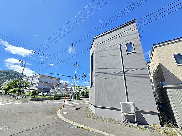 南西側から見た建物外観とカーポート。