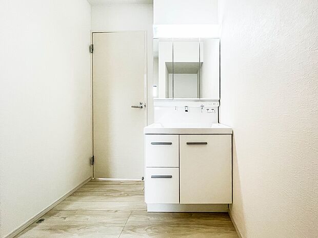 大きく見やすい三面鏡で清潔感ある洗面台は、身だしなみチェックや肌のお手入れに最適です。何かと物が増える場所だからこそ、スッキリと見映えの良い空間に拵えました。