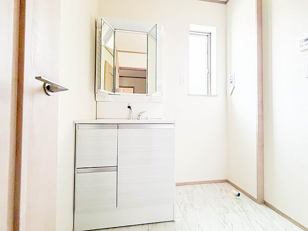 洗面室は窓の光が差し込み明るく清潔感があります。三面鏡は朝の支度が大助かり。