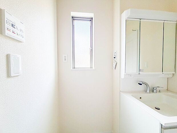 三面鏡洗面化粧台。ミラーを手前に引けば、楽な姿勢で髭剃りやメイクができます。合わせ鏡にすればヘアスタイルのチェックもラクラク。洗面化粧台のミラー裏にはたっぷり入る収納スペースを設けています。　