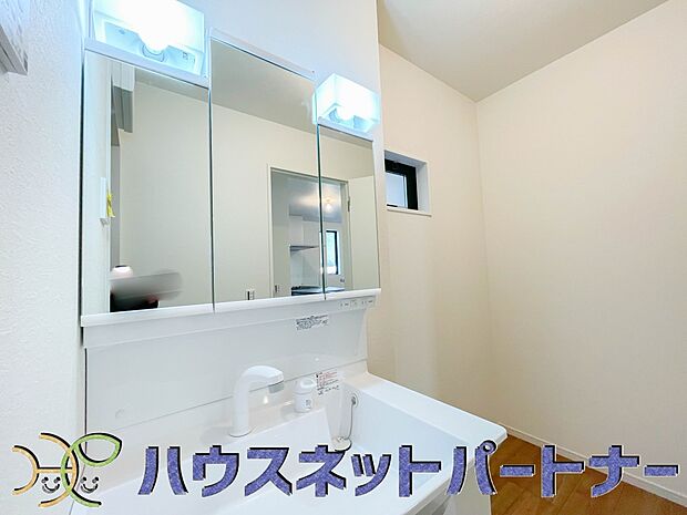 三面鏡洗面化粧台。ミラーを手前に引けば、楽な姿勢で髭剃りやメイクができます。合わせ鏡にすればヘアスタイルのチェックもラクラク。洗面化粧台のミラー裏にはたっぷり入る収納スペースを設けています。　