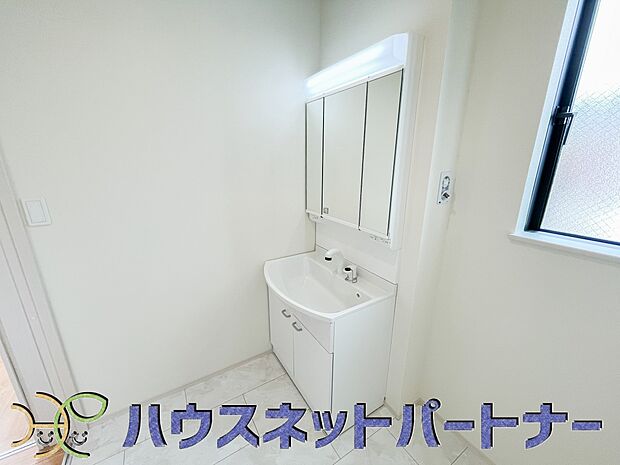 洗面室は窓の光が差し込み明るく清潔感があります。三面鏡は朝の支度が大助かり。