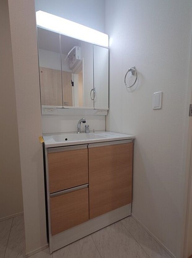 大きく見やすい三面鏡で清潔感ある洗面台は、身だしなみチェックや肌のお手入れに最適です。何かと物が増える場所だからこそ、スッキリと見映えの良い空間に拵えました。