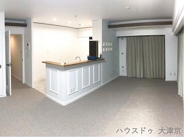 カウンターキッチンが映える広々LDK。落ち着いた色合いで、家族がくつろげる上質な空間です。