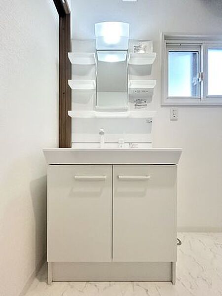【洗面化粧台】こちらは新品に交換いたしました。便利なシャワーヘッドに加え、収納スペースも付いています。整髪料などの小物も取り出しやすく散らかりません。