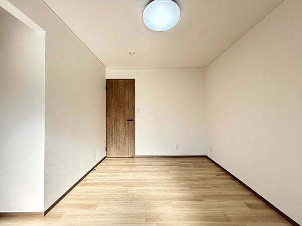 【洋室】リフォームでは、壁と床の貼替え、ドアと照明の交換を行いました。落ち着いた内装で、寝室に適した空間となっております。