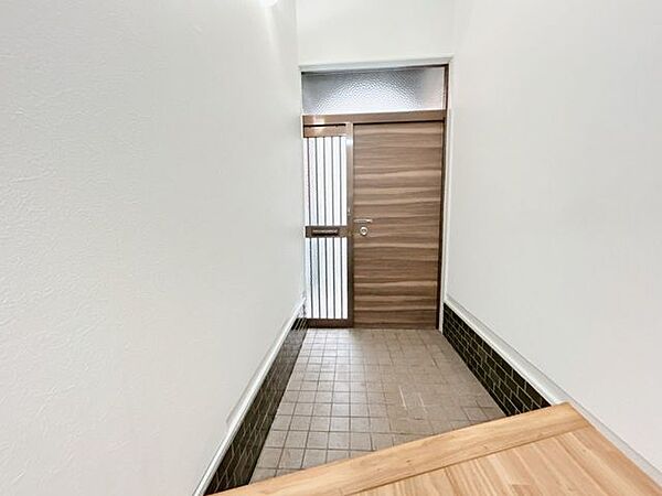 【リフォーム中】玄関ホール　クロス張替予定。照明と玄関からの光で明るい印象の廊下です。