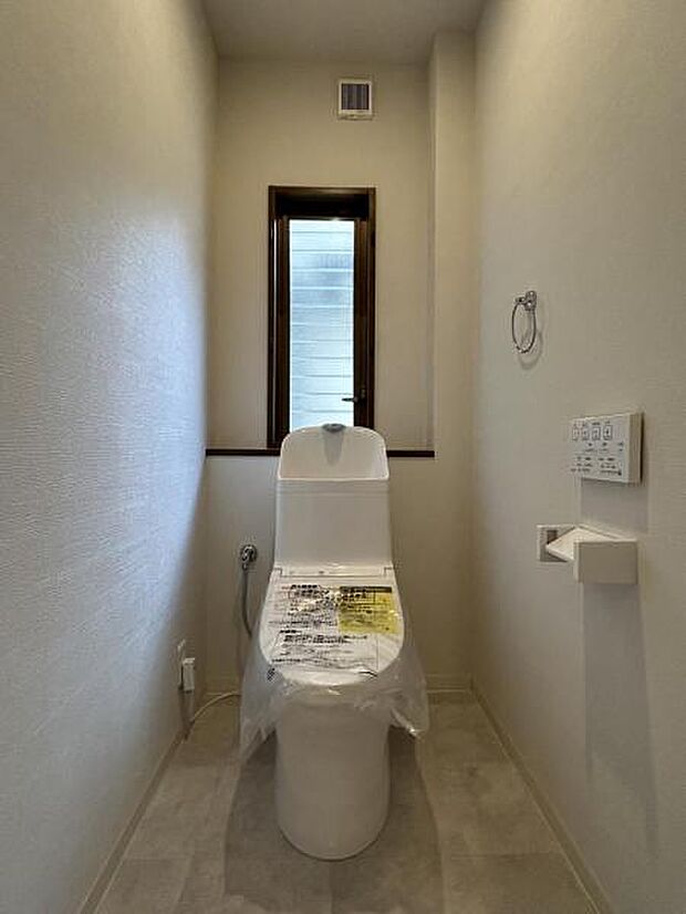 「トイレ」白色の床が清潔感のあるトイレです。窓手前にニッチがございますので、物を飾ることや収納スペースとしても活用できます。
