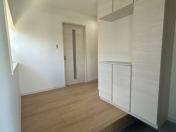 【リフォーム済】玄関内観です。床はフロア上張り、壁天井はクロス張替えを行い照明器具や配線器具も新品交換してシューズボックスも入れ替えました。