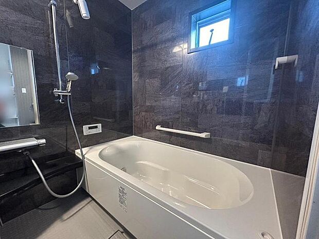 ホテルライクな石目調のアクセントパネルが印象的な浴室。