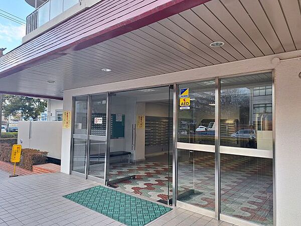 落ち着いた色調で統一されたエントランスが住む人を優しく迎え入れます。屋根付きのアプローチは雨の日でも安心感があり、建物に入る前からプライベートな寛ぎの時間を予感させる心地よい設計です