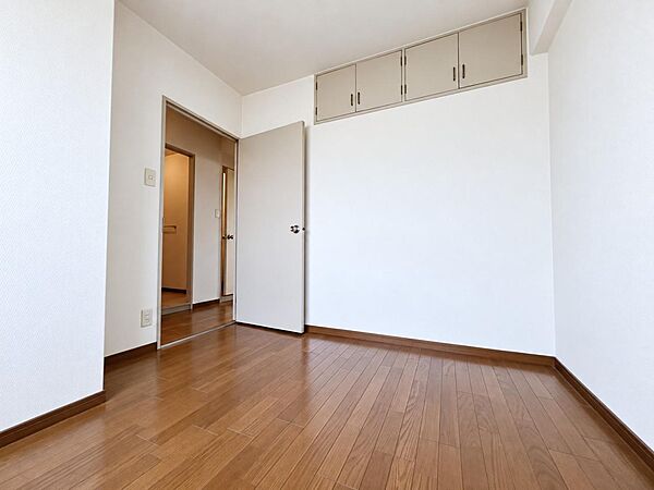 白基調に木目床が映える洋室。収納付きで家具も配置しやすい。
