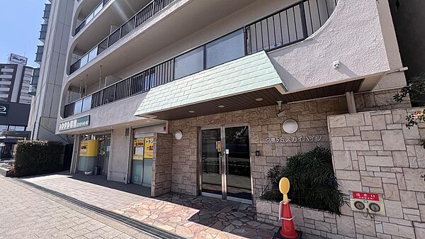 重厚な石張りエントランスが魅力。防犯カメラ付きで安心の外観。