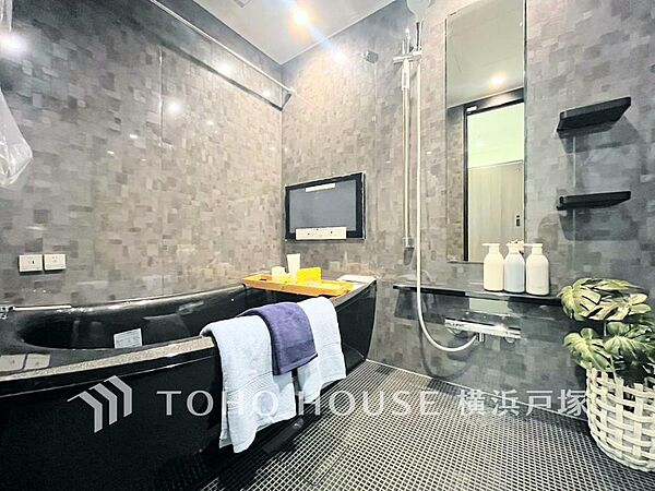 【Bathroom】まるでホテルのような上質空間。スタイリッシュな黒いバスタブと壁掛けテレビで、日々の疲れを忘れ、心ゆくまでリラックスできる浴室です。