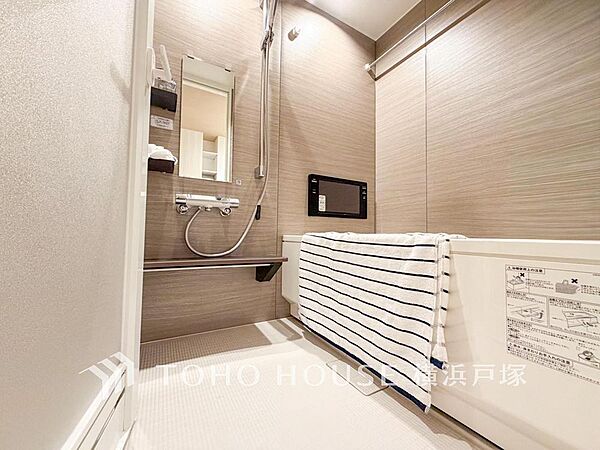 【Bathroom】木目調の壁が心地よい、モダンな浴室です。お子様とのバスタイムも快適な広々浴槽と、便利な機能で家族の毎日をサポートします。