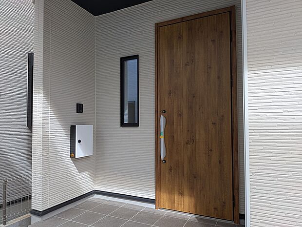 エントランス。玄関ドアに木目柄を採用