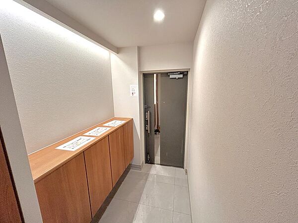 【「ただいま」が心地よく響く、落ち着いた玄関】やわらかな間接照明が空間全体をやさしく包み込み、帰宅した瞬間から穏やかな気持ちに。シンプルだからこそ、季節の小物やお気に入りの雑貨も自然と映えそうです。