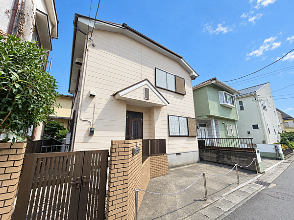 建物を斜め前方から撮影。玄関まわりや建物の佇まい、道路との位置関係が分かる一枚です。毎日の外出や帰宅の動線をイメージしながらご覧ください。