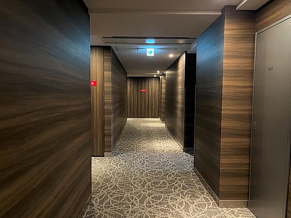 木目調の壁と模様入りのカーペットが落ち着いた雰囲気を醸し出す共用廊下。日々の暮らしに安らぎを与えます。