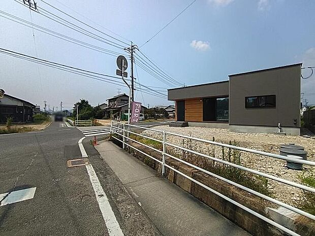 落ち着いた色合いの外観が街並みにやさしく馴染み、前道のゆるやかなカーブが住まいに穏やかな雰囲気を添えます。周辺の住宅とほどよい距離感があり、日々の暮らしを心地よく支えてくれる環境です。