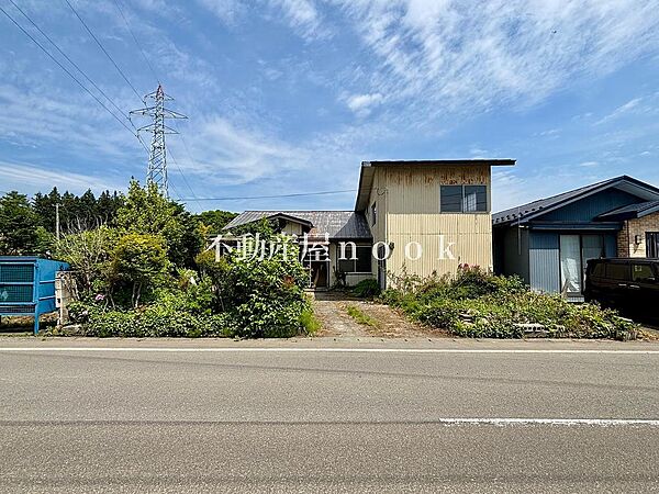 前面道路側からの外観。間口約１３ｍ、公道南側幅員約７．５ｍに接道しており、開放感のある立地です。