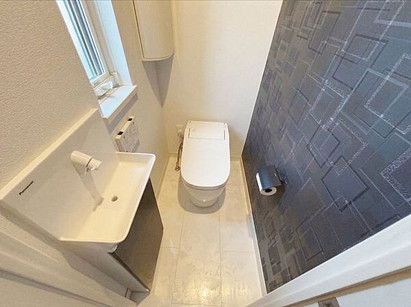 1階トイレです。タンクレストイレとなっており、手洗い場付きです。※写真はAI加工により家具等を消去しています。現況と異なる場合は現況を優先します。