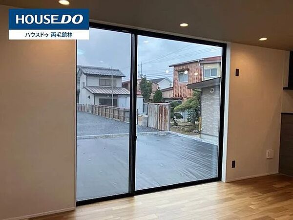 たっぷりの光を取り込む大きな窓。白と木目を基調とした温もりある空間です。