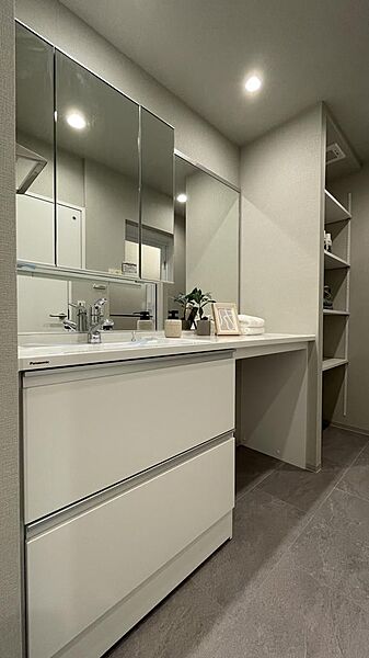 ゆとりあるカウンターが印象的な洗面台。ホテルライクな質感で、一日の始まりと終わりを優雅に整えてくれます。洗面室横には幅広の可動棚付き。