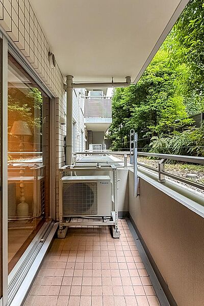 物干し金具付きのバルコニー。正面には建物の植栽が見えます。