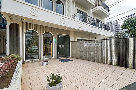 エントランス。外壁の花柄レリーフや、アーチ型のガラス窓など、愛らしい意匠が散りばめられています